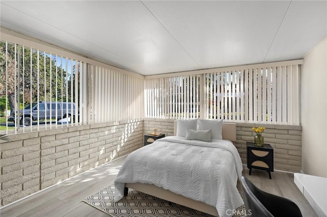bedroom with multiple windows and wood finished floors