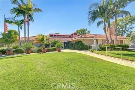 mediterranean / spanish home with a tile roof and a front yard