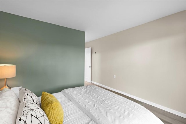 bedroom featuring baseboards and wood finished floors