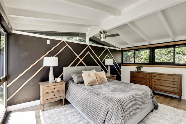 bedroom with wood finished floors and vaulted ceiling with beams