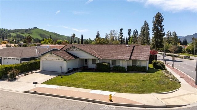 6304 Tamarind St, Oak Park, CA 91377 - ranch-style house featuring an attached garage, a front lawn, driveway, and a mountain view