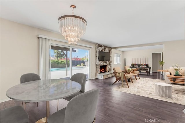 6304 Tamarind St, Oak Park, CA 91377 - dining area featuring a stone fireplace, baseboards, wood finished floors, and an inviting chandelier