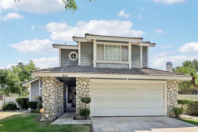 312 Barrington Cir, Redlands, CA 92374 - view of front of home featuring a garage, concrete driveway, stone siding, and a chimney