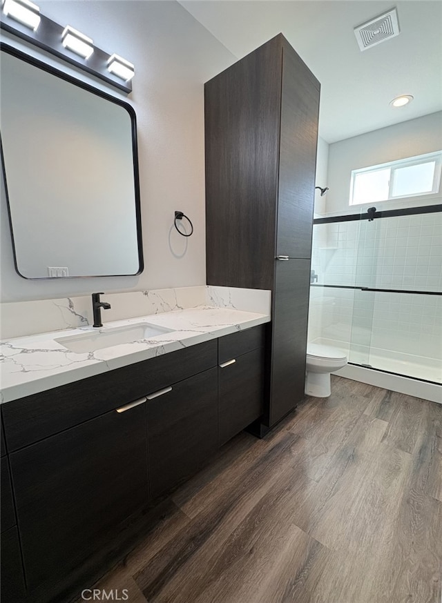 12525 Spring Valley Pkwy, Victorville, CA 92395 - full bath with wood finished floors, vanity, a tile shower, toilet, and visible vents