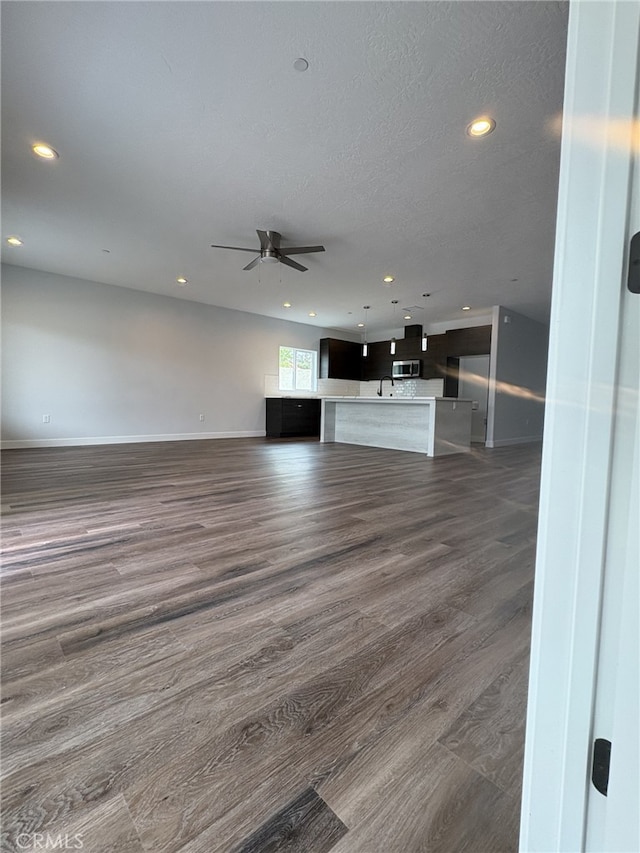 12525 Spring Valley Pkwy, Victorville, CA 92395 - unfurnished living room featuring recessed lighting, dark wood finished floors, a ceiling fan, baseboards, and a textured ceiling