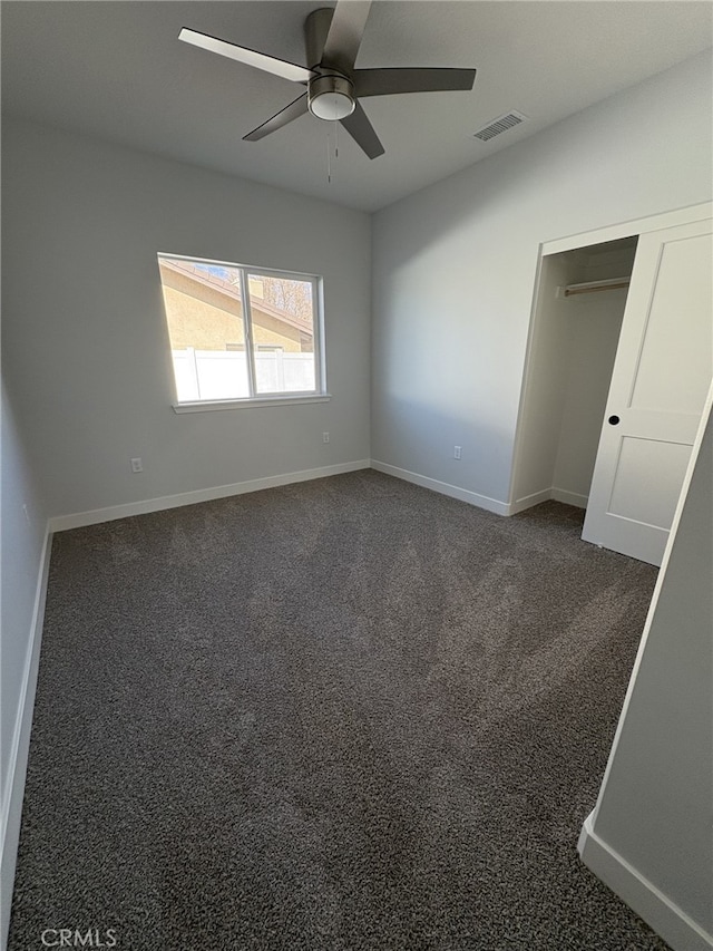 12525 Spring Valley Pkwy, Victorville, CA 92395 - unfurnished bedroom with dark carpet, ceiling fan, baseboards, and visible vents