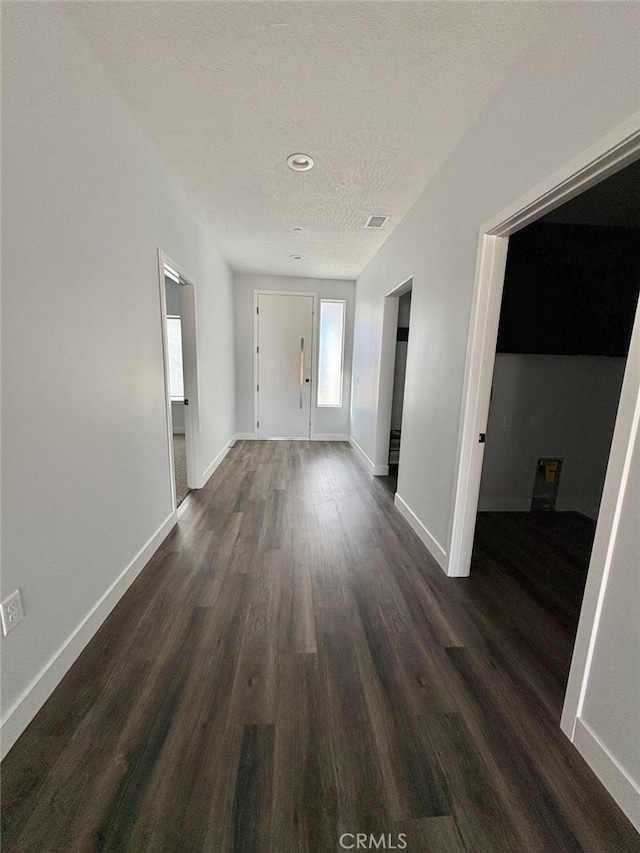 12525 Spring Valley Pkwy, Victorville, CA 92395 - hall featuring visible vents, baseboards, and dark wood-type flooring