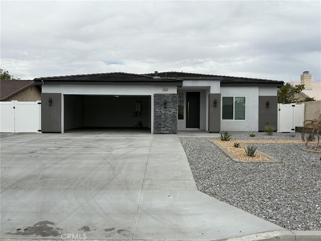 12525 Spring Valley Pkwy, Victorville, CA 92395 - prairie-style house featuring a gate, stucco siding, an attached garage, and concrete driveway