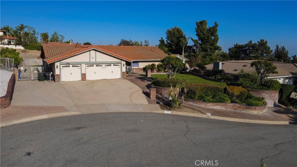 5219 Mesada St, Rancho Cucamonga, CA 91737 - ranch-style house with a gate, a tiled roof, stucco siding, concrete driveway, and a garage