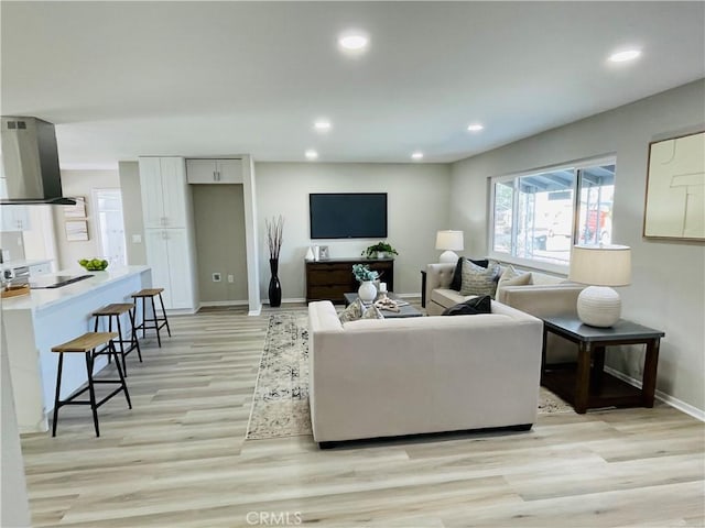 living room featuring recessed lighting, light wood finished floors, and baseboards