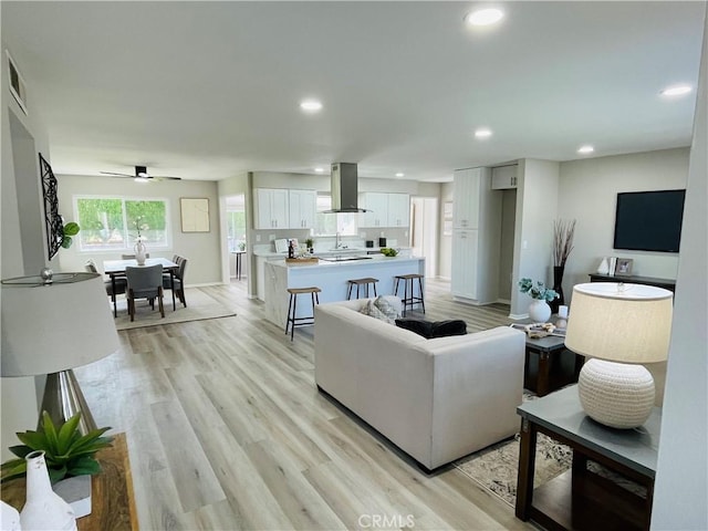 living room featuring recessed lighting, visible vents, a ceiling fan, baseboards, and light wood-style flooring