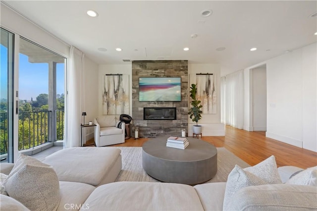 living area with baseboards, a fireplace, wood finished floors, and recessed lighting