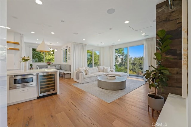 living room featuring light wood finished floors, wine cooler, and recessed lighting