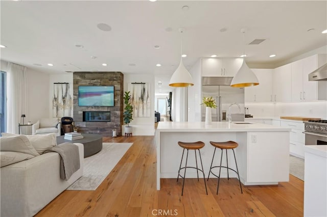 kitchen with an island with sink, white cabinetry, and high quality appliances