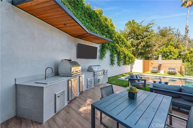 view of patio / terrace with an outdoor kitchen, grilling area, a fenced backyard, and a fenced in pool