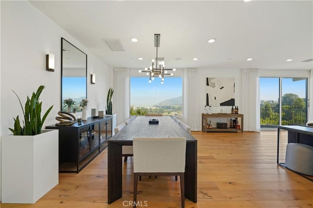 dining room with a chandelier, visible vents, light wood finished floors, and recessed lighting