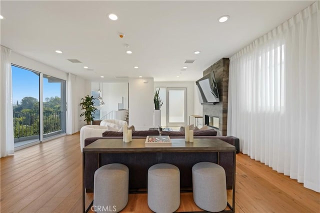 dining room featuring light wood finished floors, visible vents, a fireplace, and recessed lighting