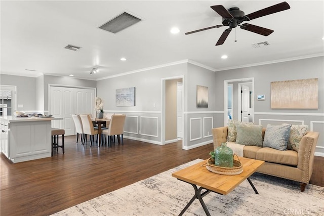 living area with crown molding, wood finished floors, visible vents, and recessed lighting
