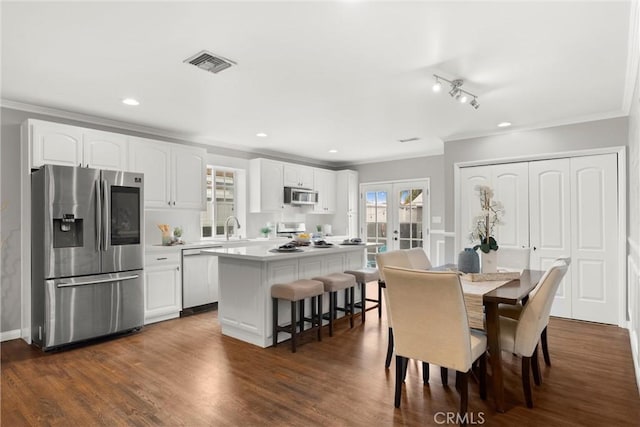 dining room with crown molding, visible vents, french doors, and dark wood finished floors