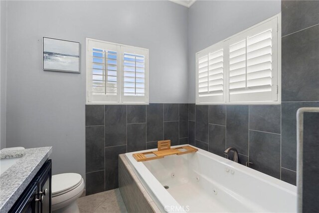 full bathroom with a jetted tub, vanity, and toilet