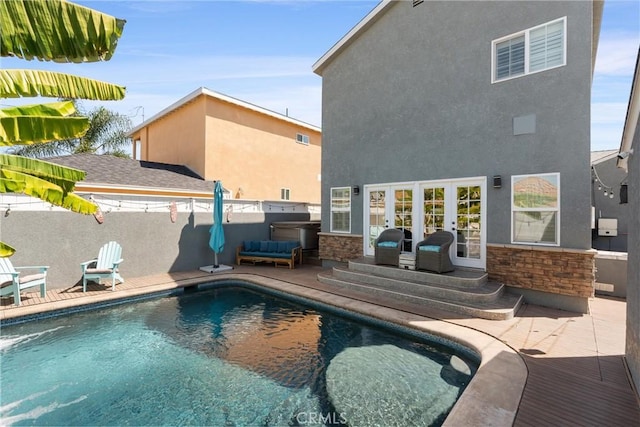 view of swimming pool featuring a fenced in pool, french doors, fence, a patio area, and an outdoor hangout area