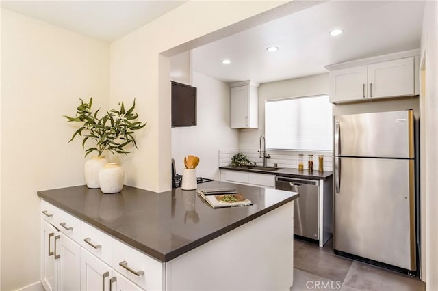 4164 Tujunga Ave Unit 102, Studio City, CA 91604 - kitchen featuring stainless steel appliances, dark countertops, white cabinetry, recessed lighting, and tasteful backsplash