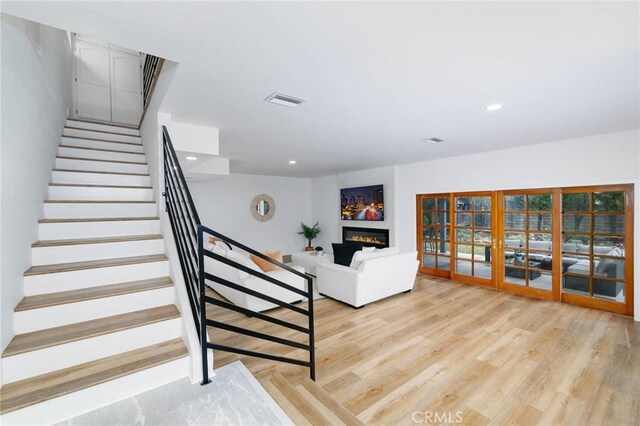 162 Acacia Ave, Monrovia, CA 91016 - staircase with wood finished floors, a glass covered fireplace, recessed lighting, and french doors