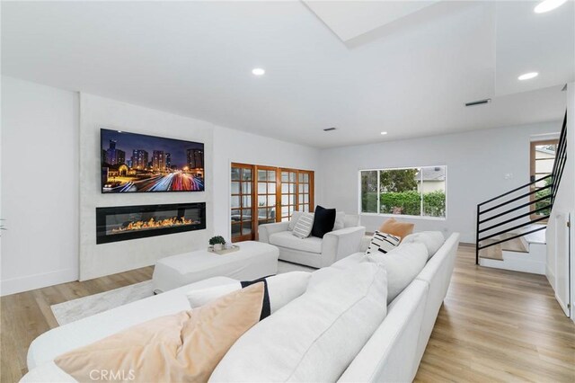 162 Acacia Ave, Monrovia, CA 91016 - living room with a glass covered fireplace, light wood-style floors, stairs, and recessed lighting