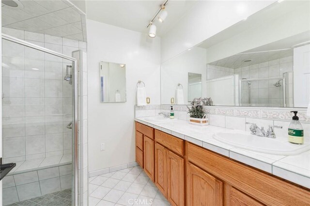 162 Acacia Ave, Monrovia, CA 91016 - bathroom featuring a shower stall, tile patterned flooring, double vanity, and tasteful backsplash