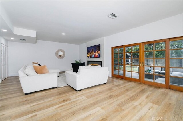 162 Acacia Ave, Monrovia, CA 91016 - living area with french doors, light wood-style floors, a glass covered fireplace, and recessed lighting