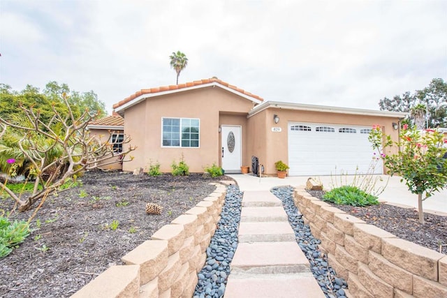 view of front of home with stucco siding, driveway, and an attached garage