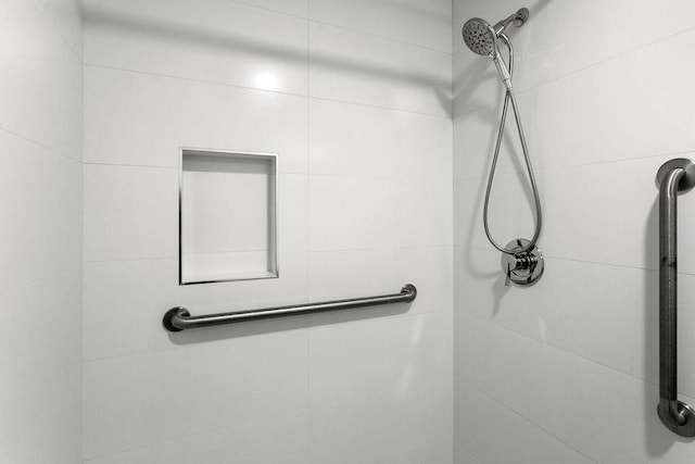 interior details featuring tiled shower
