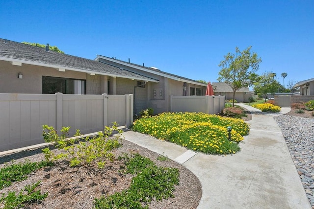 view of front of property featuring fence and roof with shingles