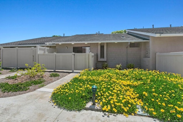 single story home with fence and roof with shingles