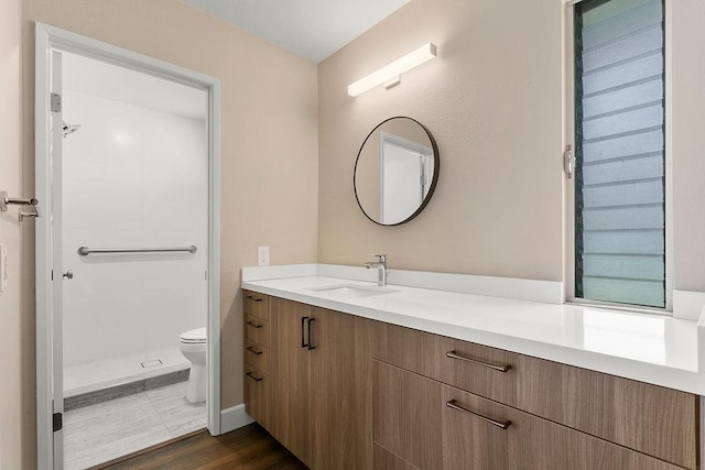 full bath with vanity, toilet, and tiled shower
