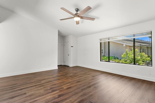 spare room featuring baseboards, a ceiling fan, and dark wood-style floors