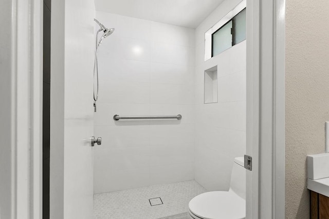 full bath with toilet and tiled shower