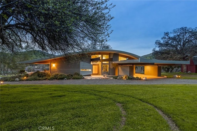 prairie-style house with a carport, driveway, and a front yard