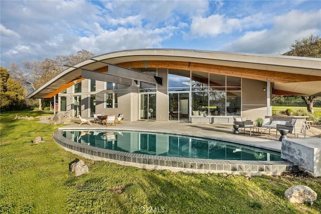 outdoor pool with a lawn and a patio