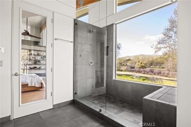 ensuite bathroom with ensuite bathroom, a mountain view, tile patterned flooring, and a tile shower
