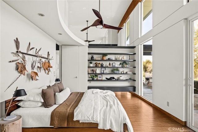 bedroom with wood finished floors and access to exterior