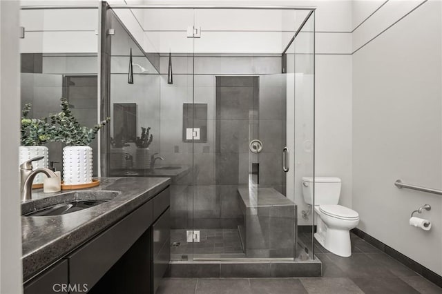 full bath featuring a shower stall, tile patterned floors, vanity, baseboards, and toilet