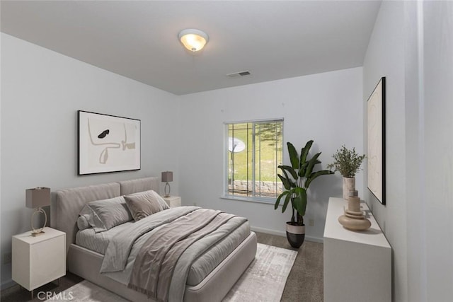 carpeted bedroom featuring baseboards and visible vents