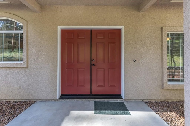 view of exterior entry with stucco siding