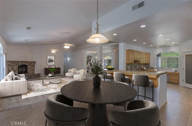 dining space with a fireplace, visible vents, and light tile patterned floors