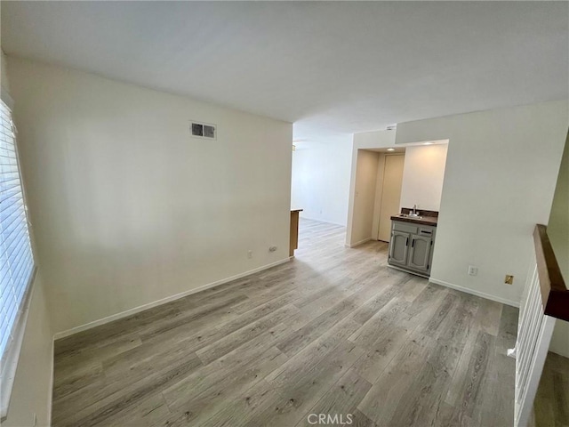 5444 Las Virgenes Rd, Calabasas, CA 91302 - spare room with plenty of natural light, light wood finished floors, visible vents, a sink, and baseboards
