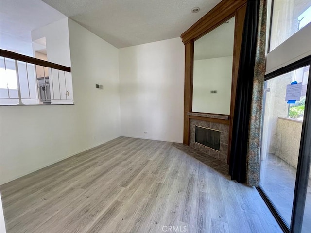 5444 Las Virgenes Rd, Calabasas, CA 91302 - unfurnished living room featuring light wood-type flooring and a tiled fireplace