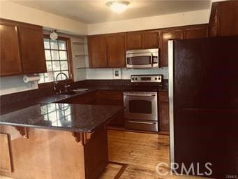 1150 Pacific Blvd, Oceano, CA 93445 - kitchen with stainless steel appliances, a sink, light wood-type flooring, a peninsula, and a kitchen bar
