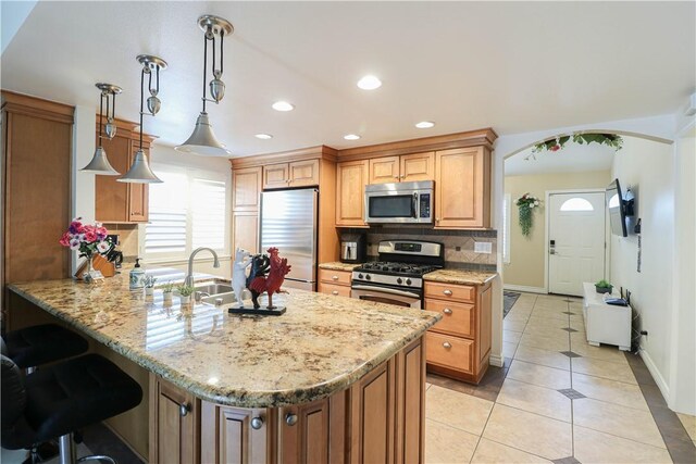 10629 El Este Ave, Fountain Valley, CA 92708 - kitchen featuring stainless steel appliances, a peninsula, a sink, light tile patterned flooring, and backsplash