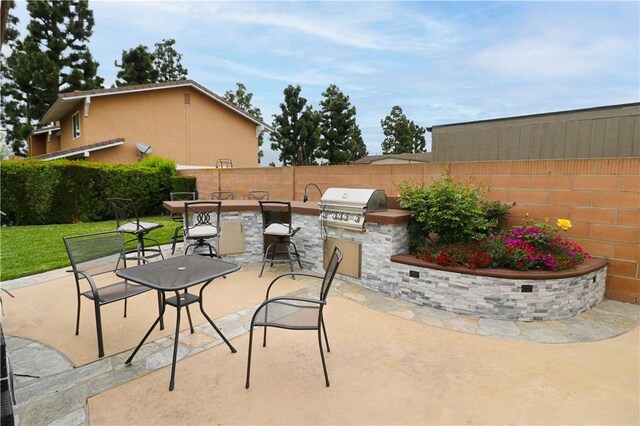 10629 El Este Ave, Fountain Valley, CA 92708 - view of patio / terrace with an outdoor bar, an outdoor kitchen, a fenced backyard, and area for grilling